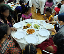 慈濟志工恭敬地為照顧戶奉上特別為他們而準備的菜餚和白米飯。【攝影者：吳澤明】
