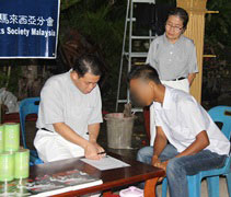 慈濟志工羅漢升（左一）協助受災鄉親登記資料。【攝影：劉碧綠（慈函）】