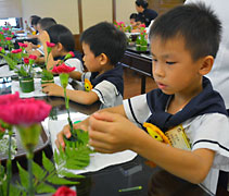在花道老師的帶動下，小朋友們用心學習，完成佈置畢業典禮的花藝。【攝影者：王幼晶（懿昀）】