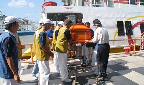 慈濟志工在玻璃市港口碼頭協助搬運遺體棺木。【攝影者：胡健發（濟肯）】