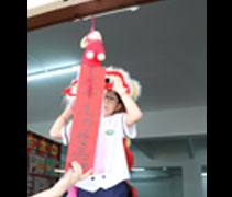 小朋友耍着威武的舞獅，把寫着“小小羊兒力行三好”的春聯打開了。【攝影者：林霞君】