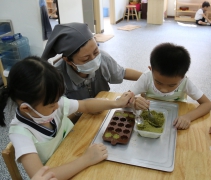 慈濟師姑正用心指導幼兒園裡六歲班的小朋友作餅幹。【攝影者：林霞君】