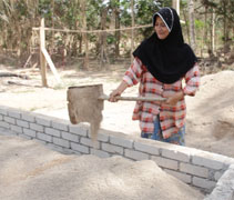53歲的莎瑪每天與80歲老母親輪流將沙子鏟入還沒完工的地基裡, 希望幫忙加速弄好地基後就可以盡快組裝簡易屋了。【攝影者：藍錦菲】
