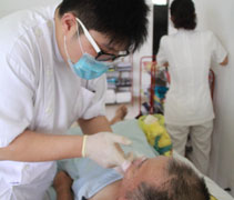 護士幫陳碹惜的先生清理口腔，保持衛生，希望可以讓他過得舒服一些。【攝影者：杜慮晞】