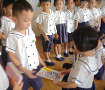 四歲班的小朋友將他們準備捐出的書籍，交給六歲互愛樂樂班的小朋友，讓他們送愛到孤兒院。【攝影者：林雪淇】
