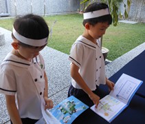 溫景騰（右）與其他同學在慈濟幼兒園領取「蔬果護照」，準備繼續與家人一起持素護生。【攝影者：何麗英】