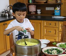 貼心的溫景騰為家人盛飯，準備享用晚餐。【攝影者：翟佩庭】