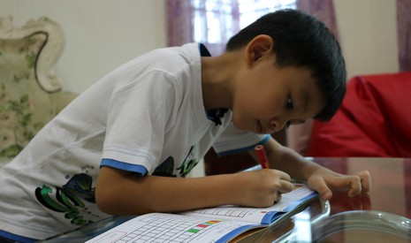 今年五歲的溫景騰，在「蔬果護照」上認真留下一家人茹素的記錄。【攝影者：翟佩庭】