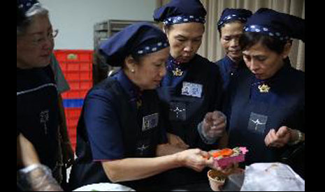 馬來西亞團隊在黃秀鳳〈左二〉師姊的號召下用心研發各式菜色。【攝影者：陳美玉】