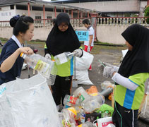 慈濟志工徐秋玲（慮容）細心教導兩位馬來裔學生做分類：大件塑料瓶子可用繩子綁一起，小件的可以在歸類後放進袋子裡，這樣會節省善後時搬運的時間。【攝影者：董雪貞】