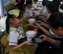 六歲班的小朋友雙手奉上一杯茶和餐點，給師長們享用。【攝影者：劉燕燕】