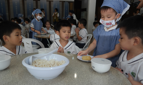 香積小菩薩黃宇雄，雙手奉上一碟鹹豆腐，讓同學們享用。【攝影者：顏美芬】