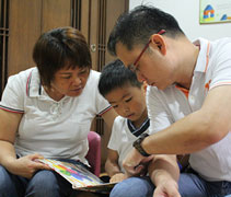 在等待檢查的當兒，家長們陪同孩子一起閱讀繪本。【攝影者：林雪淇】