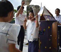老師為在蔬果護照活動中達成目標的幼兒別上勳章以示肯定。【攝影者：許證勝（濟韡）】