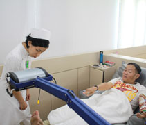 慈濟洗腎中心的護士孫慧萍關心腎友張源豐腳趾的傷口。【攝影者：杜慮晞】