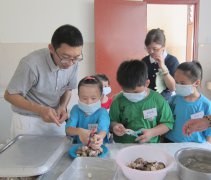 「學習，要有如小鳥學飛的精神，不怕跌倒，不怕失敗，直到學成為止。」在隊輔的指導下，小朋友小心翼翼地學切菜。【攝影者：江詩雯】