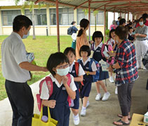 孩子們喝完涼茶之後，志工再分發口罩給他們，雙重守護孩子的健康。【攝影者：王維信】