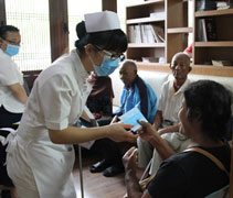 吉打洗腎中心的護理師分發口罩給腎友及家屬，並叮嚀大家減少外出。【攝影者：尤靜蓓）】