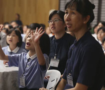 現場播放回顧短片，回顧親子們之前上課的種種，小朋友嘴上輕輕哼唱並隨着播放的音樂比劃手語，童心未泯！【攝影者：丘笑菱】