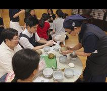 淨斯團隊黃錦梅（慈升）師姊耐心的指導大德們如何用手把荷葉飯壓得更紮實。【攝影者：邢薇薇】