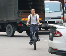 早晨七點左右，張仁豪踩著自行車，穿梭在熙熙攘攘的車陣中，準備展開忙碌的一天。【攝影者：顏如艷】