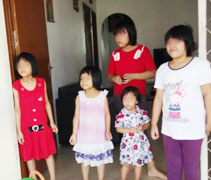 露絲蒂娜的5名女兒在家門口看著家裡一件一件家具一一搬上羅里，心情喜憂參半。【攝影者:翁麗燕（慈合】 