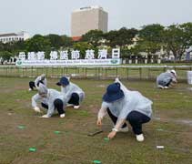 下午兩點多下了雨。大家擔心延誤，雨一小就穿起雨衣繼續打地標。【攝影者：王榮海】