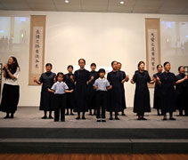 志工和小朋友們配合萬芳的演唱「讓愛傳出去」表演手語。【攝影者：李志旺】