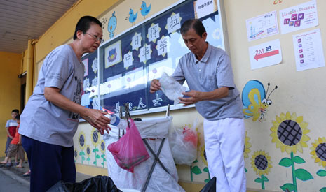陳華莉女士（左）在志工設立的回收站幫忙進行分類。【攝影者：許薇盈（懿礽）】