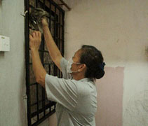 志工吳鳳蘭又是抹窗，又是爬高擦電風扇，把照顧戶的家當做自己的家來打掃，法喜滿滿。【攝影者：何勝雄】