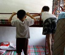 打掃完畢，一名傢俱商在房間裡把慈濟結緣的雙層單人床架組裝起來後，孩子們興奮地爬上床。【攝影者：李漢明（濟恕）】