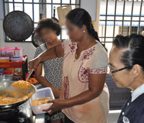 照顧戶穆儒給彡的太太珊迪（Santhiy）協助志工，在家準備印度傳統食物--米餅和黃豆醬料給照顧戶們晚餐。【攝影者：林兆南】