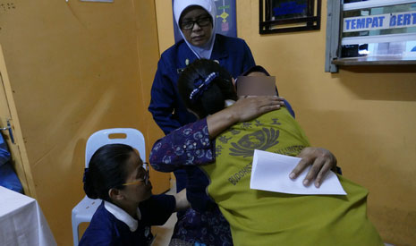 慈濟志工為一名馬來裔死者的家屬恭讀證嚴上人的慰問信後，遞上慰問金，也給她一個溫暖的擁抱，願她安身也安心。【攝影者：戴佳玉（慈迪）】