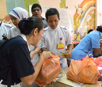 慈濟志工吳桂春（慈縝）分發民間團體捐出的食物給醫護人員。【攝影者：黃綉英（慈錦）】