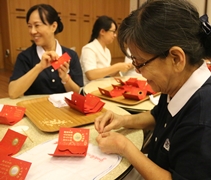 志工以歡喜心製作福慧紅包，把祝福送到民眾手裡。【攝影者：尤靜蓓（慮忱）】