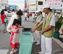 志工指導民眾資源分類，放入適當的回收桶。【攝影者：蔡東湘】