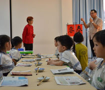 曾慶仁老師向小朋友們介紹「春」的象形字由來，紅衣者為另一位書法老師鄭月明。【攝影者：劉曉秀】