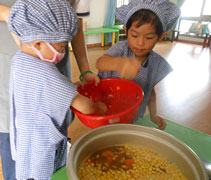 蔡信宏（左）和溫景桐（右）把切好的蘿蔔丁放進電飯鍋裡煮。【攝影者：翟佩庭】