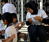 檳城幼兒園學生在Mira老師的指導下拆卡帶。【攝影者：黃翊晴】