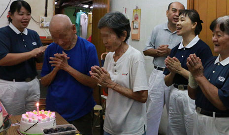 志工請阿嬤許生日願望，然後阿公阿嬤一起吹蠟燭，切蛋糕。【攝影者：張愛璇】