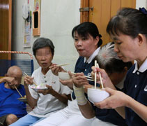 平常節儉的老人家，擔心這麼多食物吃不完，一直請志工吃多一點。【攝影者：張愛璇】