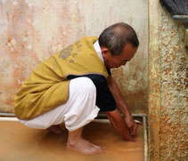 慈濟志工朱德發（本諾）協助疏通遭淤泥阻塞的排水孔。【攝影者：陳志財（濟庭）】