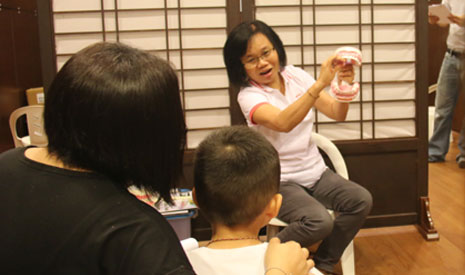 檢查牙齒前，人醫會成員向家長與孩子講解刷牙的正確步驟及保護牙齒的方式。【攝影者：陳慧潔】