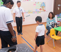 廖晉輝醫生（左二）檢查小朋友的足弓，若發現有扁平足問題，則教導家長如何改善足弓異常的扁平足問題。【攝影者：翟佩庭】