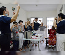 打掃完畢後，拉妮亞姆和志工們在乾淨整潔的客廳，一起演繹馬來語版〈一家人〉（Kita Satu Keluarga）手語，意喻即使沒有血緣關係，彼此之間也可以是一家人。志工還準備了一些食物，讓大家一起享用。【攝影者：方莉敏】