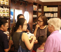 慈濟志工向請購香積飯的民眾何春連（右一）和她的女兒、媳婦分享香積飯多樣化的食用方法。【攝影者：何威明】