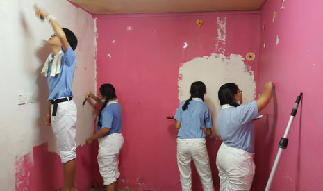 慈少們在狹小的空間裡，開始將已經開裂斑駁的漆面鏟掉，和粉刷牆壁。【攝影者：黎合強】