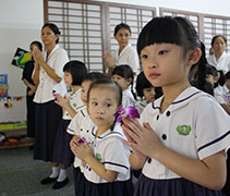 北海慈濟幼兒園學生在禮佛後，手新小心翼翼的握着佛花，靜心等待他人禮佛。【攝影者：洪繪萍】