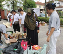 幼兒園的家長茜蒂努拉（Siti Nura，右二）第一次來到慈濟環保點，環保點站長何麗英（右一）向她講解可以分類及回收的物資 。【攝影者：劉玉容（慮化）】
