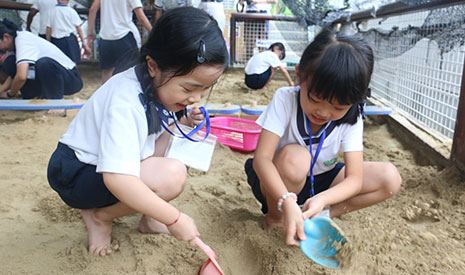 孩子們奮力挖掘教職員事前埋藏在沙池中的食材造型玩具，在過程中體驗農民的艱辛，了解食物來之不易。【攝影者：黃翊晴】